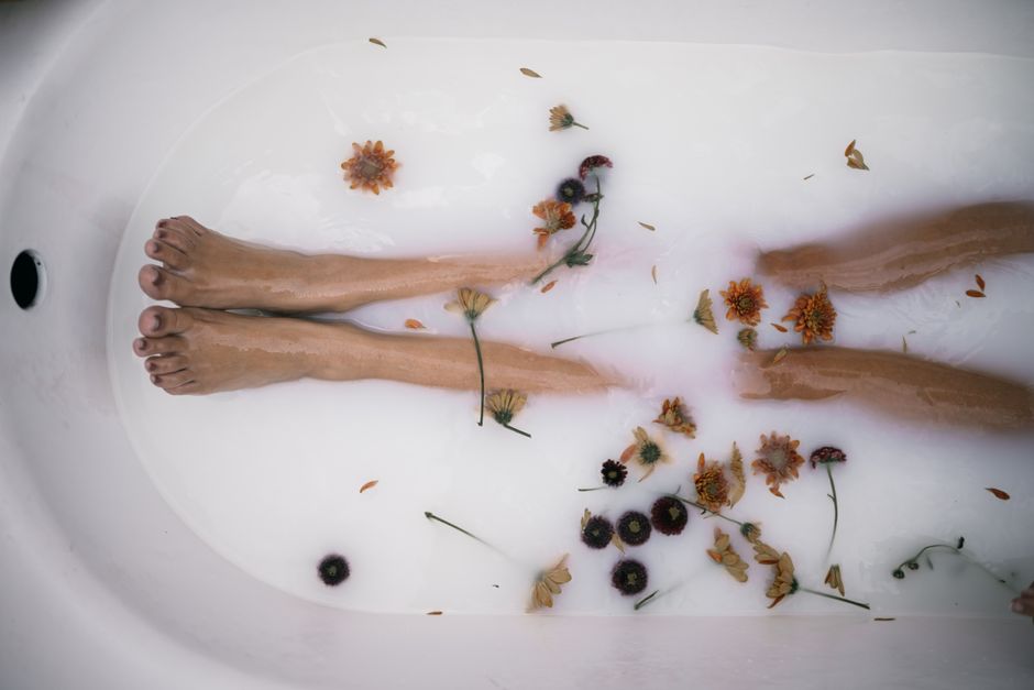 Femme faisant tremper ses pieds dans un bain chaud avec bicarbonate de soude pour soulager les douleurs plantaires